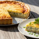 Frisch gebackene Käse-Quiche mit goldbrauner Käsefüllung, ein Stück auf Teller angerichtet – Käse-Wähe Rezept